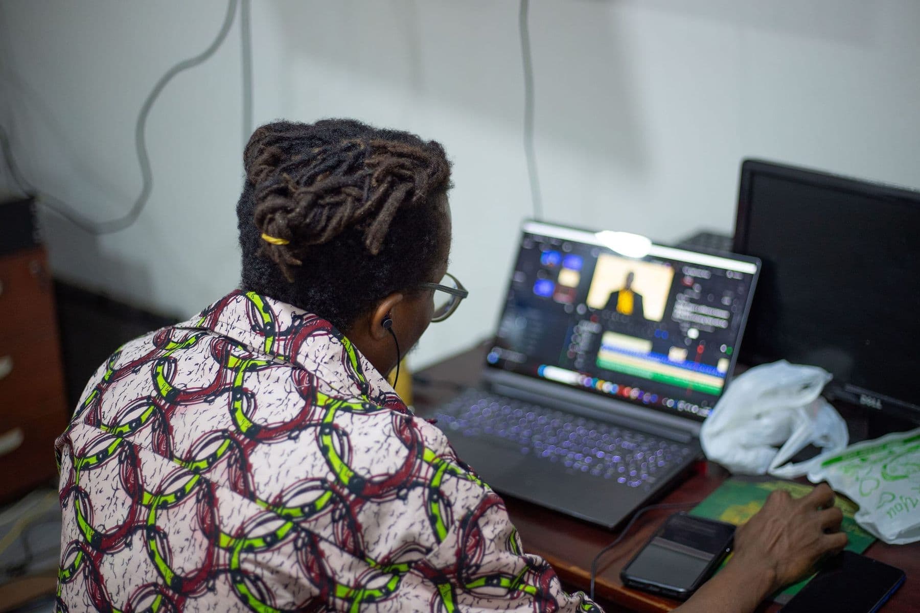 Video editor cutting footage on a laptop timeline at a desk