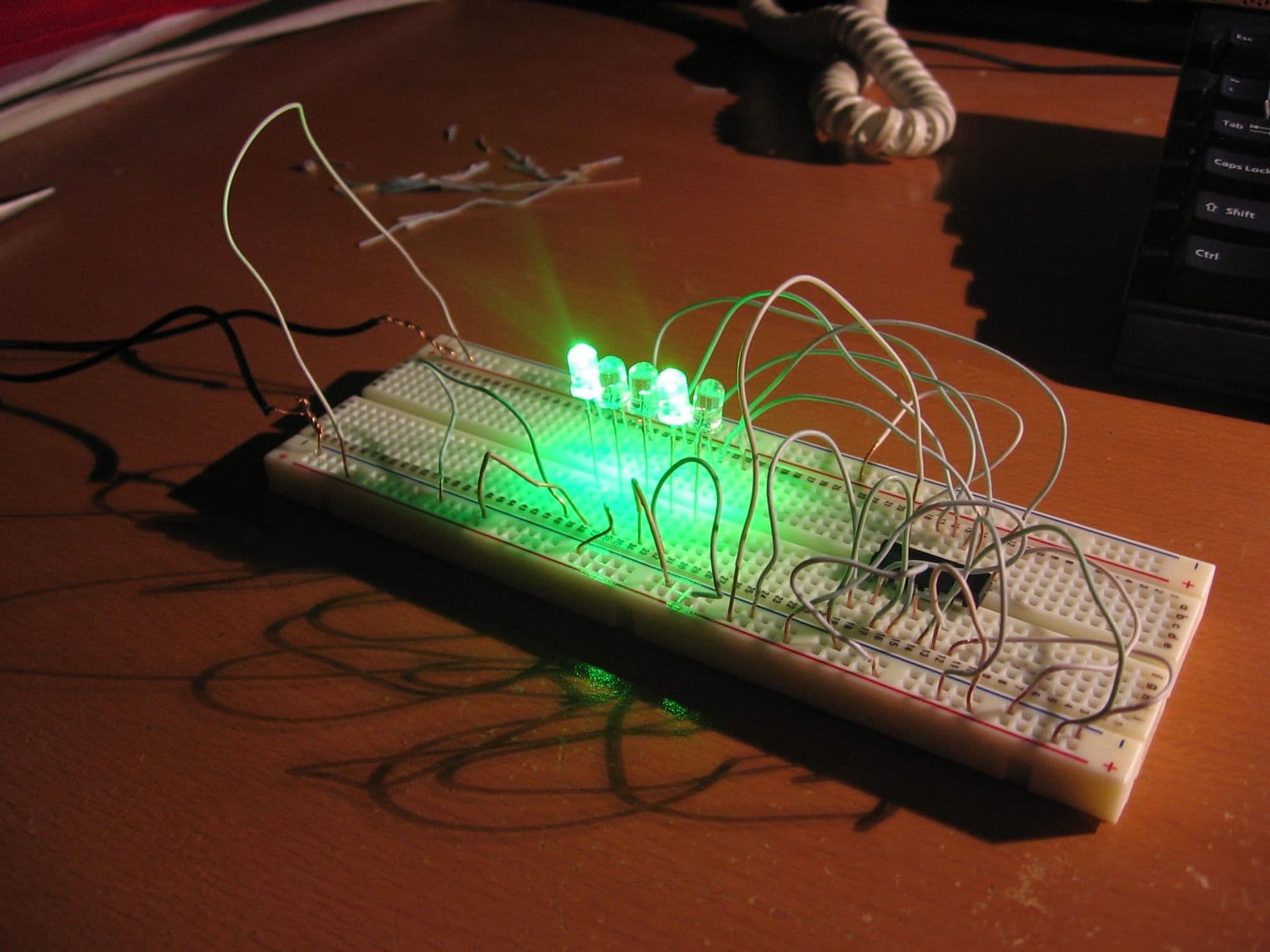 მწვანე LED-ები ანთია დაფაზე (breadboard), სადენებით აწყობილი ელექტრონული წრედი