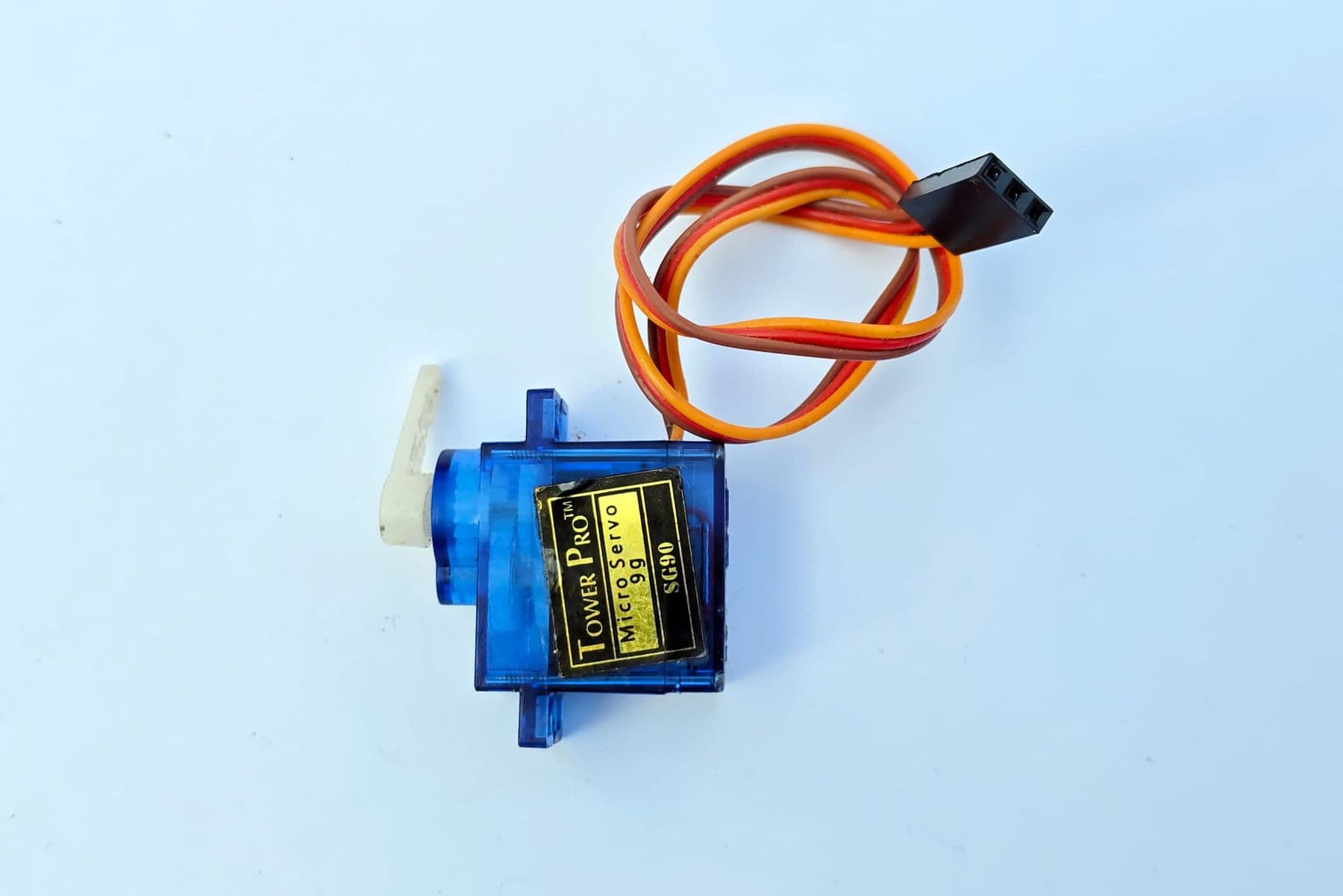SG90 micro servo motor with its three-wire brown, red and orange cable