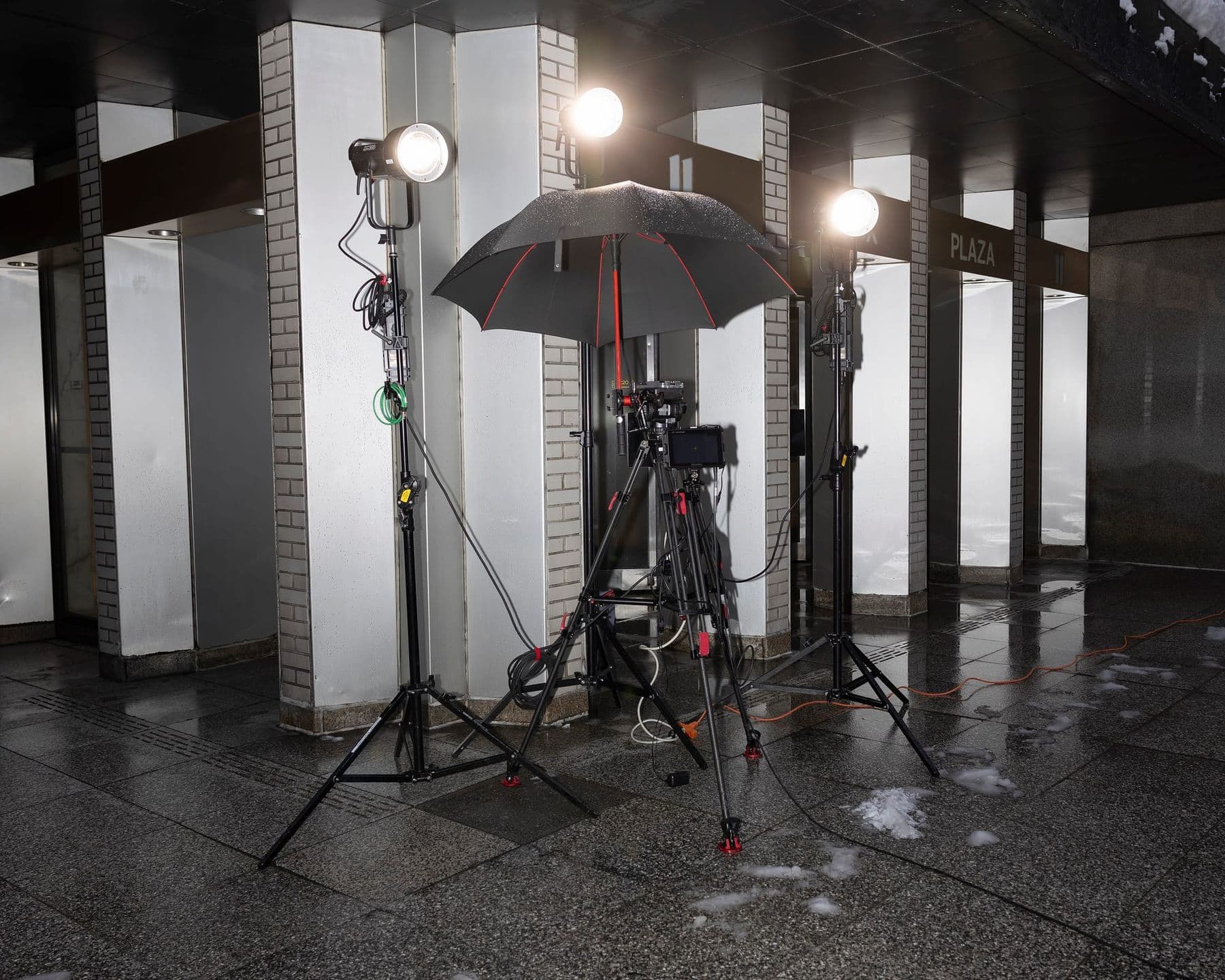 Camera on a tripod with three lights on a small video shoot location