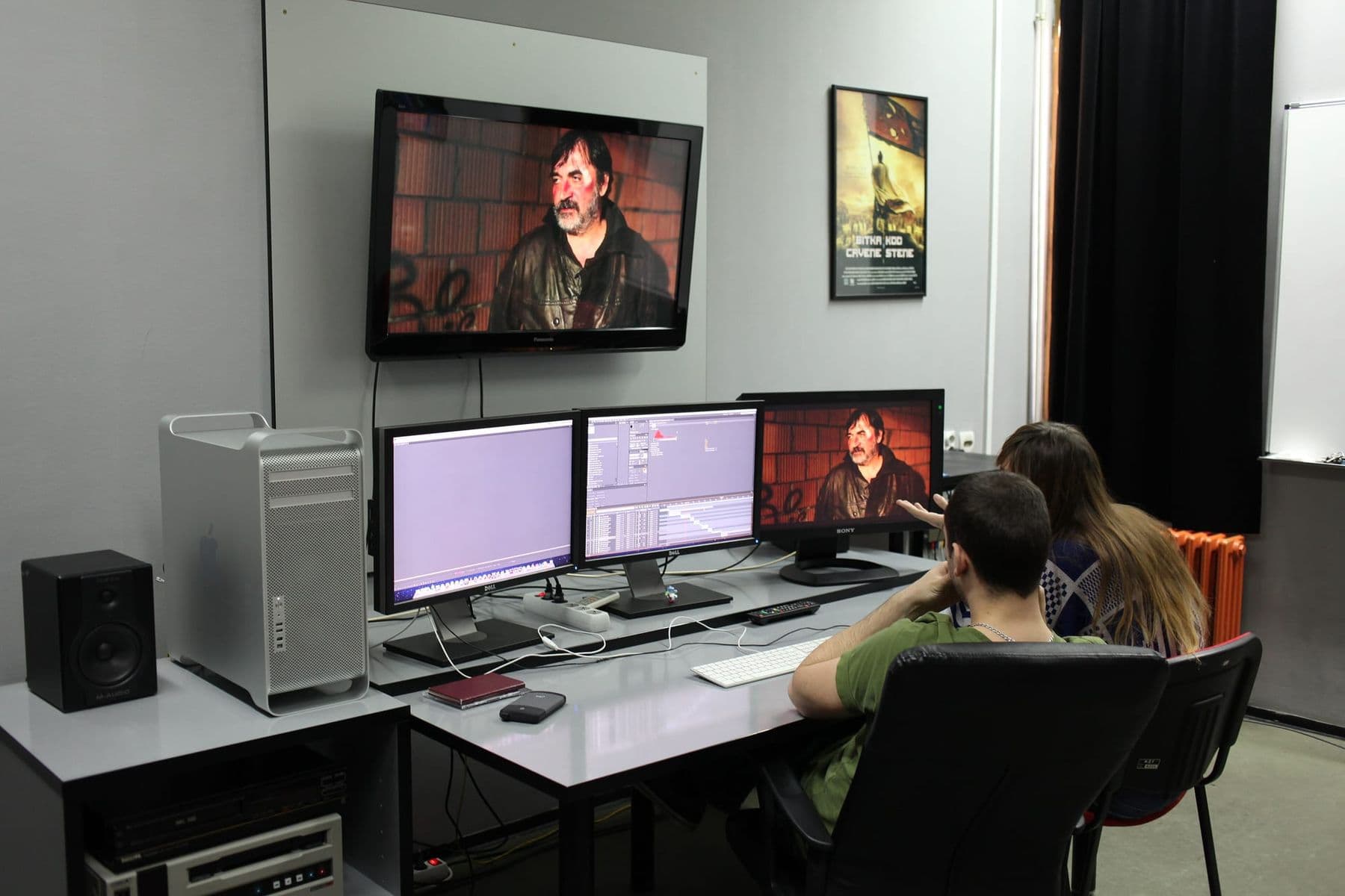 Video editors working at several monitors in an editing room