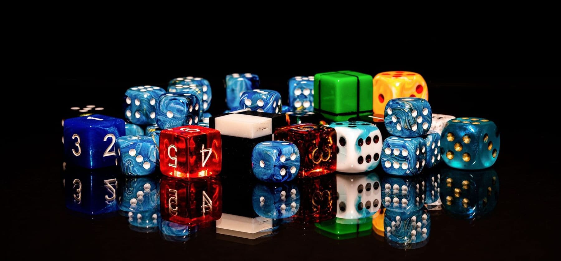 Colourful dice on a black background, fun maths and probability