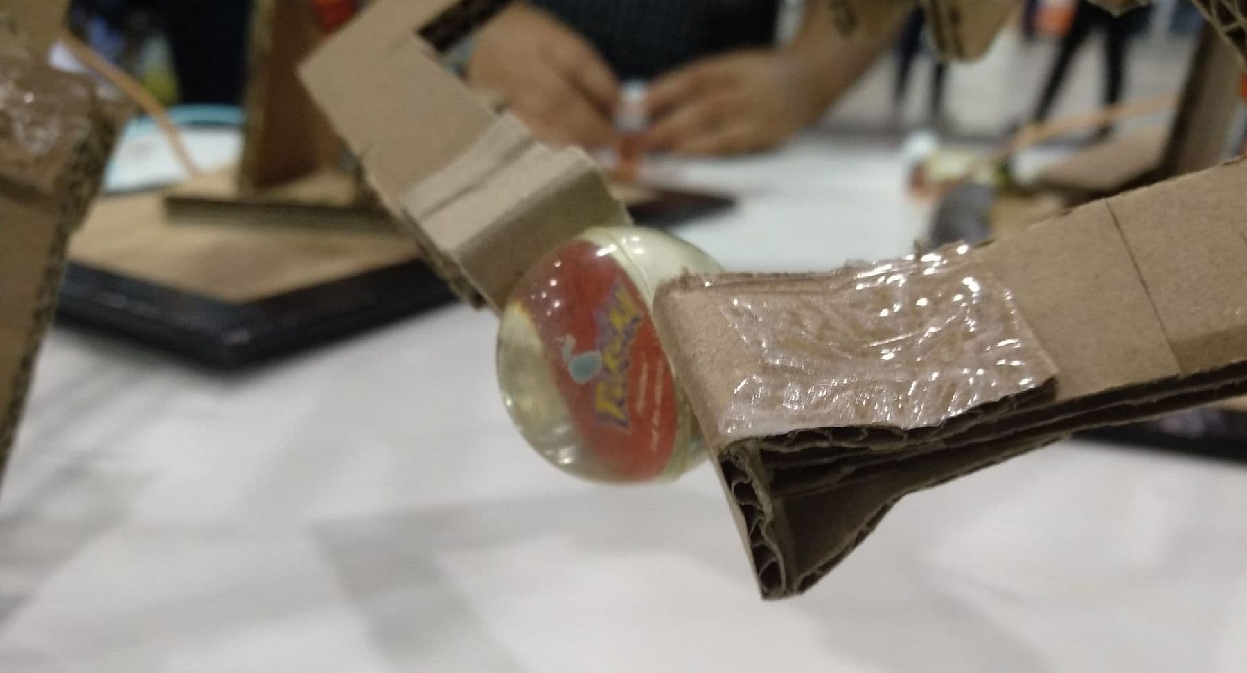 Cardboard robotic arm gripper holding a small ball: a robotics project at home