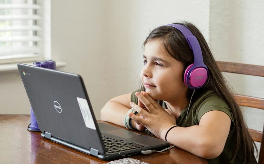 Girl with headphones studying at a laptop